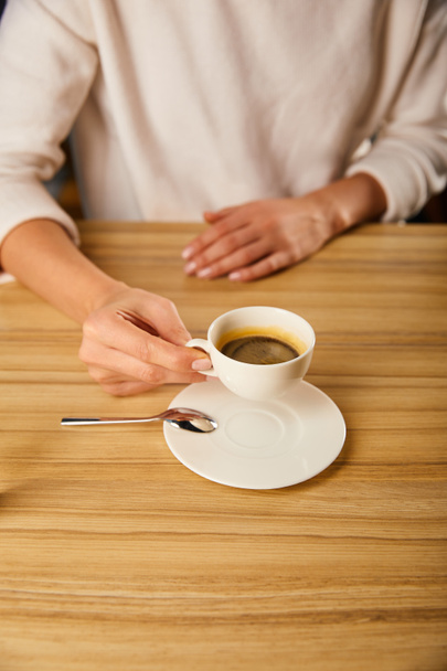 vista recortada de la mujer sosteniendo taza con café caliente en la cafetería
  - Foto, imagen