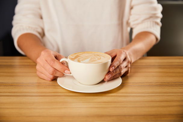 vágott kilátás nő gazdaság csésze cappuccino  - Fotó, kép