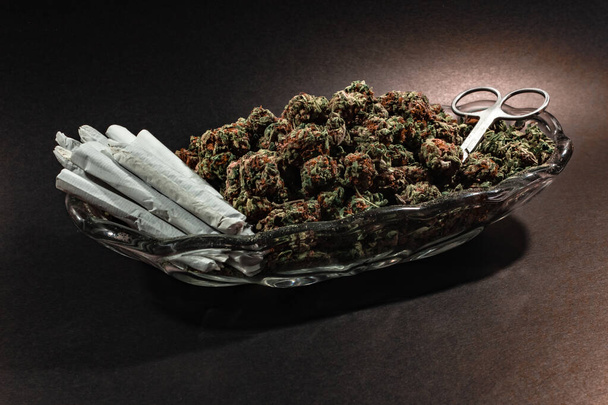 Stijlvolle glazen schaal met marihuana knop, schaar en een dozijn scharnieren - Foto, afbeelding