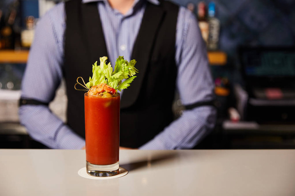 vue recadrée du barman près d'un cocktail Mary ensanglanté avec céleri et crevettes en verre
  - Photo, image