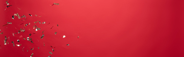 Blick auf goldenes Weihnachtskonfetti isoliert auf rot mit Kopierraum - Foto, Bild