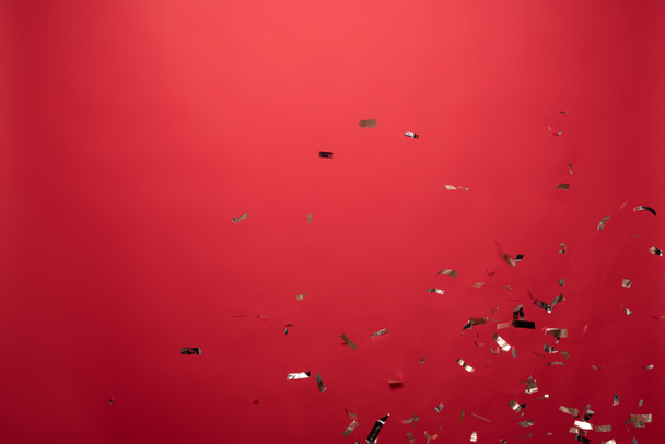 view of golden confetti isolated on red with copy space - Foto, Imagem