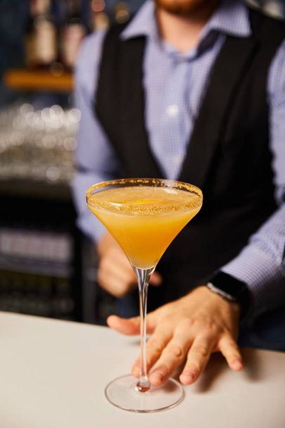 vista recortada de barman sosteniendo vaso de margarita con cóctel frío
  - Foto, imagen