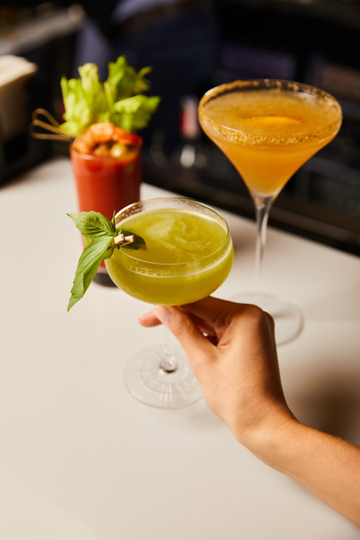 cropped view of woman holding margarita glass with fresh cocktail - Foto, afbeelding