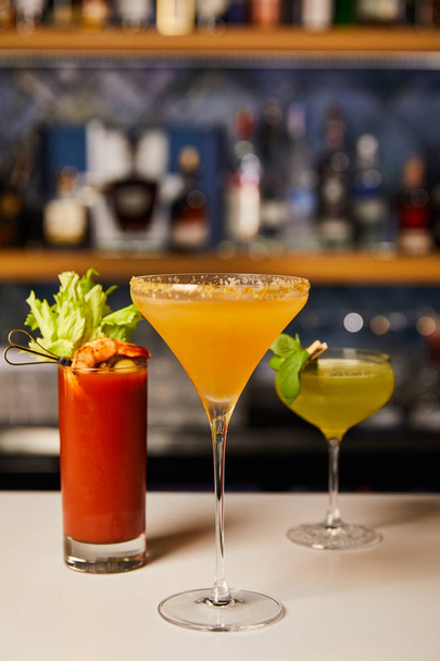 selective focus of mixed and fresh cocktails in glasses on bar counter  - Photo, Image