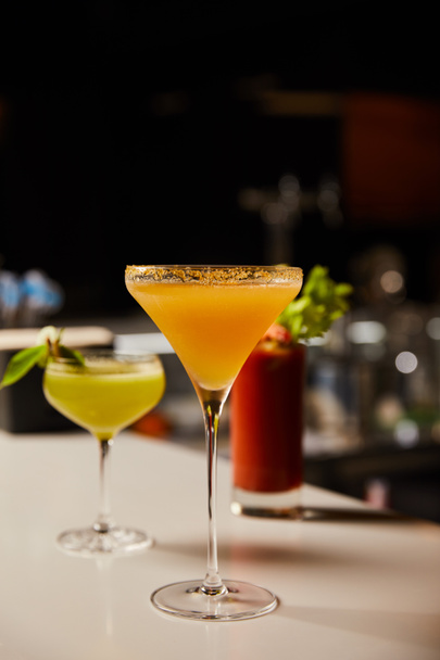 selective focus of mixed cold cocktails in glasses on bar counter  - Photo, Image