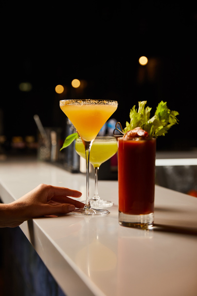 vue recadrée de la femme touchant verre de margarita avec cocktail frais sur comptoir bar
  - Photo, image
