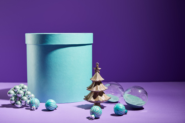 boîte cadeau bleu et arbre de Noël décoratif avec des boules sur fond violet
 - Photo, image