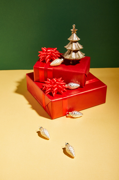 cajas de regalo rojas y decoración de Navidad dorada sobre fondo amarillo y verde
 - Foto, imagen