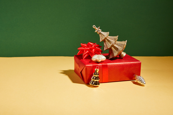 red gift boxes and golden Christmas decor on yellow and green background - Foto, immagini