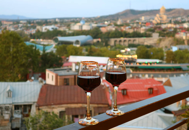 Paire de verres à vin sur le balcon avec vue aérienne floue sur la ville en toile de fond
 - Photo, image