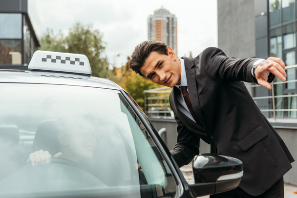 Empresário apontando algo para motorista de táxi na rua
 - Foto, Imagem