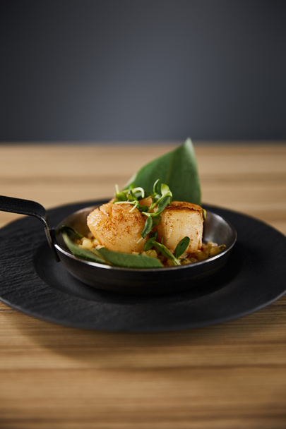 delicious grilled scallops with green leaves and microgreens on wooden table on black background - Photo, Image
