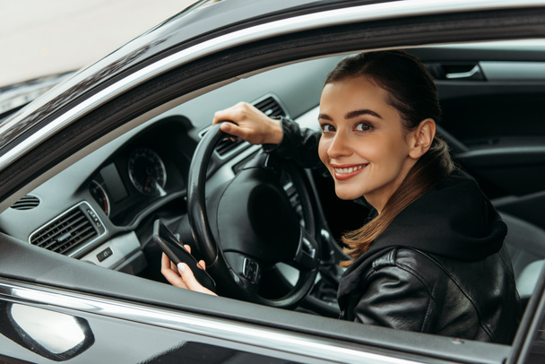 Sourire femme chauffeur de taxi tenant smartphone dans la voiture
 - Photo, image