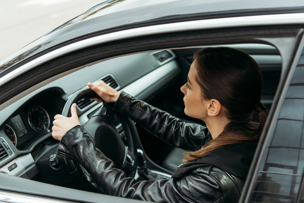 Πλευρική όψη του γυναικείου οδηγού ταξί που κρατά τιμόνι - Φωτογραφία, εικόνα