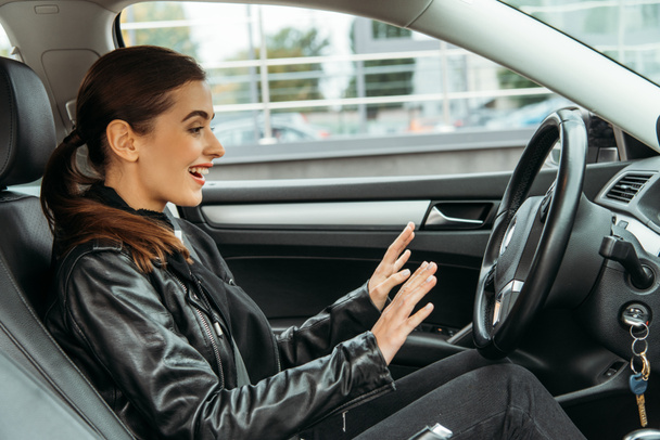 Захоплена усміхнена жінка на водійському сидінні безпілотного автомобіля
 - Фото, зображення