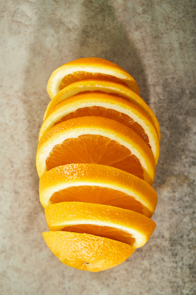 πάνω όψη του τεμαχισμένου και ώριμου πορτοκαλιού σε μαρμάρινη επιφάνεια  - Φωτογραφία, εικόνα