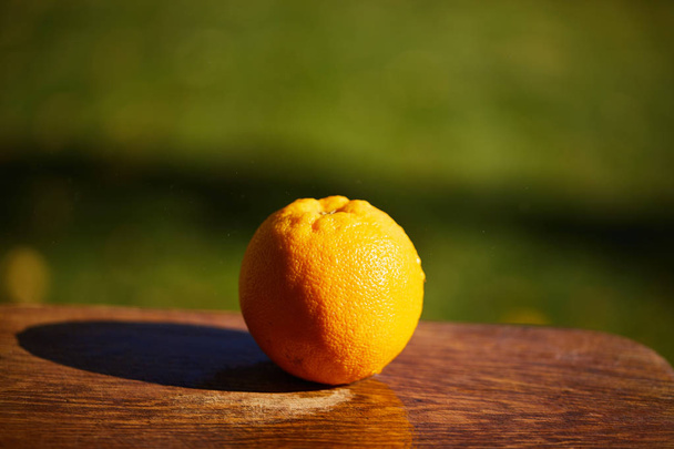 selective focus of whole and ripe orange on wooden cutting board - Fotografie, Obrázek
