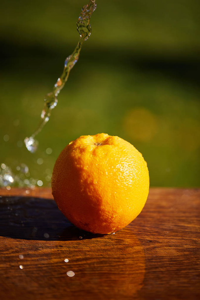 selective focus of whole and wet orange on wooden surface  - Foto, afbeelding