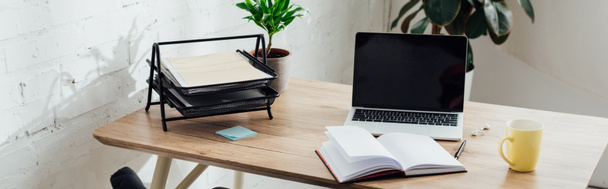 Notebook, laptop met blanco scherm en beker op werktafel, panoramisch shot - Foto, afbeelding