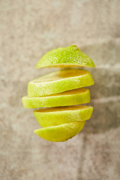 top view of sliced and ripe lime on marble surface  - Foto, imagen
