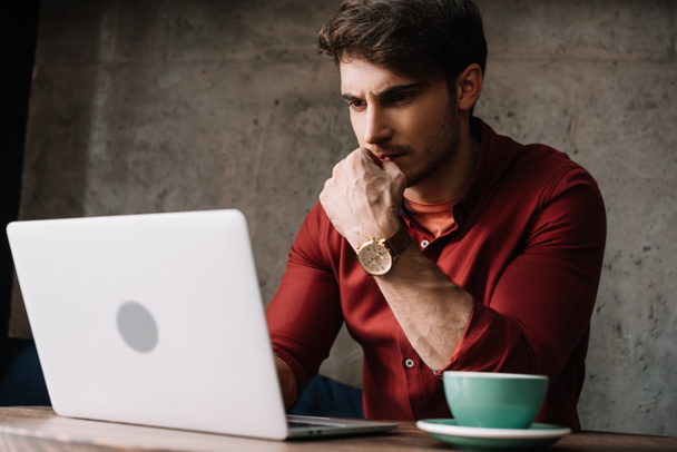 attente jonge freelancer werkt aan laptop en het drinken van koffie in de coffeeshop - Foto, afbeelding