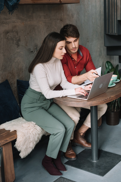 young couple working on laptop in modern coffee shop - Фото, зображення