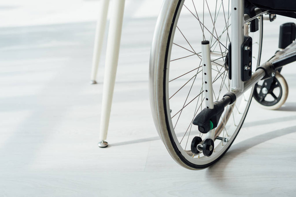 Close up view of wheelchair by table legs - Photo, Image