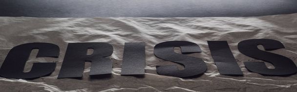 plano panorámico de crisis palabra negra sobre papel simbolizando agua sobre fondo negro con iluminación
 - Foto, Imagen
