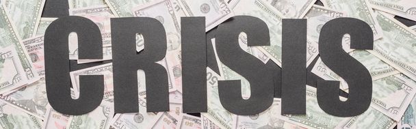 Draufsicht auf Schwarzwortkrise auf verstreuten Dollarnoten, Panoramaaufnahme - Foto, Bild