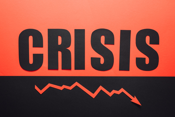 bovenaanzicht van woordcrisis en recessie pijl op zwarte en rode achtergrond horizontaal verdeeld - Foto, afbeelding