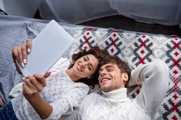 vista de ángulo alto de novia atractiva y novio sonriente en suéter mirando tableta digital
  - Foto, imagen