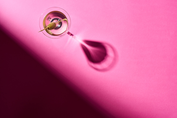 Top view of vermouth with olive on pink surface - 写真・画像