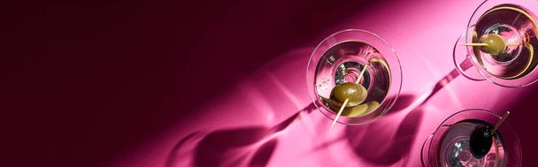 Top view of martini cocktails on bright pink background with shadows, panoramic shot - Photo, image