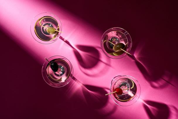 Top view of cocktails with olives on pink background with shadows - Photo, Image