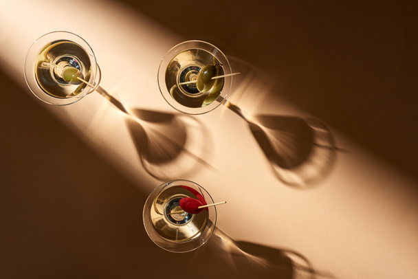 Top view of martini cocktails with olives on beige background - Foto, afbeelding