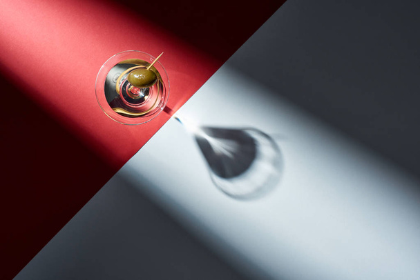 Top view of martini with shadow on red and grey background - Foto, afbeelding