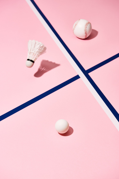 Tenis, beysbol ve badminton topları mavi çizgili pembe yüzeyde. - Fotoğraf, Görsel