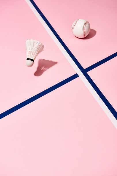 Baseball and badminton shuttlecock on pink surface with blue lines - Valokuva, kuva