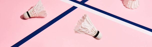 Shuttlecocks for badminton on pink background with blue lines - Foto, afbeelding