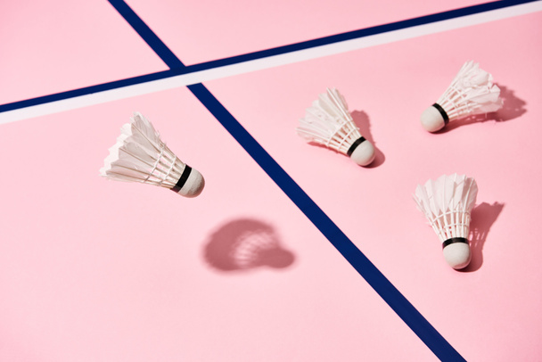 White badminton shuttlecocks on pink background with blue lines - Fotoğraf, Görsel