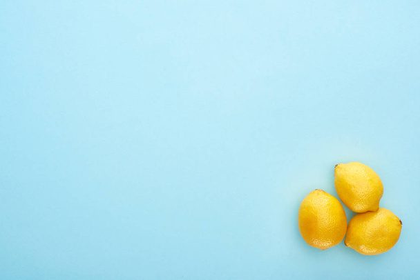 top view of ripe yellow lemons on blue background with copy space - Фото, зображення