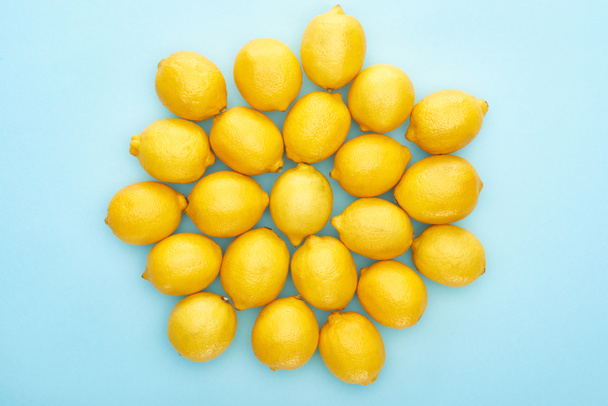 top view of ripe yellow lemons on blue background - Foto, Imagen