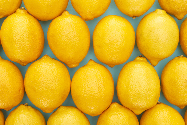 top view of ripe yellow lemons on blue background - Valokuva, kuva