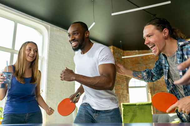 Young people playing table tennis in workplace, having fun - Fotó, kép