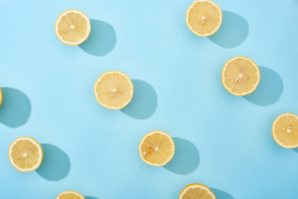 вид зверху на стиглий розріз жовтих лимонів на синьому фоні
 - Фото, зображення