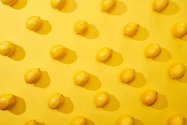 top view of ripe lemons on yellow background - Foto, imagen