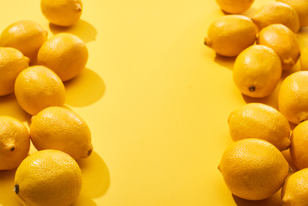 verse rijpe hele citroenen op gele achtergrond met kopieerruimte - Foto, afbeelding