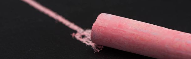 close up view of pink chalk on black surface with drawn line, connection concept - Foto, immagini