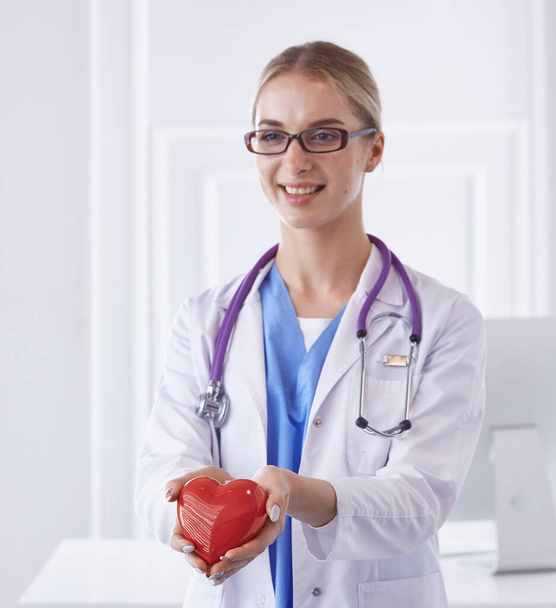 Doktor se stetoskopem drží srdce, izolované na bílém pozadí - Fotografie, Obrázek